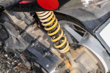 Bir atölyede motosikletin süspansiyon sisteminin karmaşık detaylarını araştır.