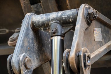 İnşaat alanındaki ağır makinelerin hidrolik silindirinin yakın görüntüsü..