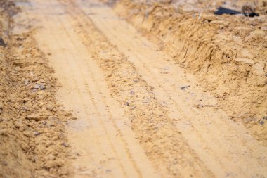 Kırsal kesimde kaydedilen ilerlemeyi gösteren bir inşaat yolunun yakın çekim görüntüsü.