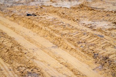İnşaat çalışmalarının etkisini gösteren kumlu arazideki ağır makinelerin izlerini araştırın..