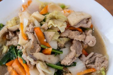 Canlı bir yemek. Kızarmış domuz ve taze sebzeler en iyi ev yemeklerini sergiliyor..