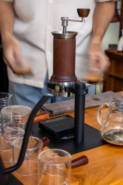 Sıcak bir kahve dükkanında zanaatkar bir aletle yapılan titiz kahve demleme işlemine tanık olun..