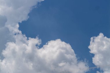 Yumuşak bulutların berrak mavi gökyüzüne karşı dingin güzelliğine tanık olun..
