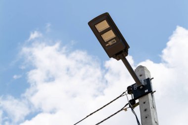 Modern bir sokak lambasının yakın plan görüntüsü şehir merkezinde bir direğe monte edildi ve şehrin aydınlatmasında yenilik sergilendi..