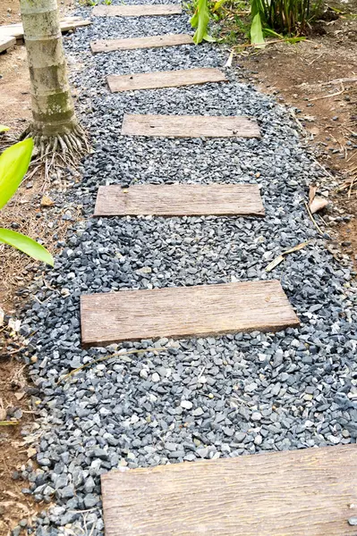 Güzel bir taş patika, açık havada doğal malzemeler ve sakin tasarım sergilenen bir bahçeye çıkıyor..