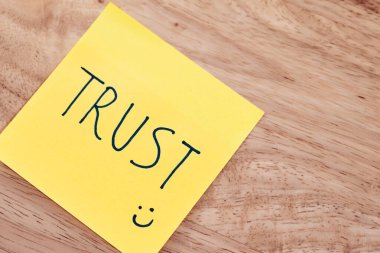 Trustin kelimesini gösteren yapışkan bir notun yakın plan görüntüsü pozitif iş yeri bağlantılarını teşvik eden profesyonel bir ayar.