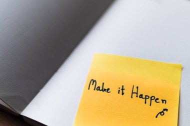 Motivasyonel bir deyimin olduğu yapışkan bir notun yakın plan çekimi üretkenliğe ilham verir..