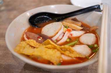 Canlı bir kase baharatlı şehriye çorbası sıcak bir yemek atmosferinde taze malzemeler ve kalın tatlar sergiler..