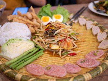 Canlı Tayland pazarında taze malzemelerin sergilendiği renkli bir papaya salatası ziyafeti yaşayın..