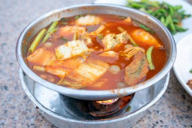 Kalabalık bir sokak pazarında hazırlanmış otantik kimchi güvecinin canlı lezzetlerinin tadını çıkarın..