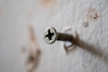 DIY ev projelerinin hassasiyetini gösteren bir duvara vida monte edilişinin ayrıntılı bir yakın çekimi.