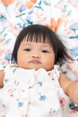 Bir yaşındaki Asyalı bir kızın portresi. Masumiyetini ve çekiciliğini ev ortamında yakalıyor..