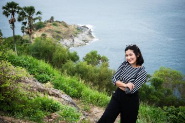 Bir gezgin, yemyeşil ve dingin sularla çevrili Tayland 'ın çarpıcı kıyı manzarasının tadını çıkarır..