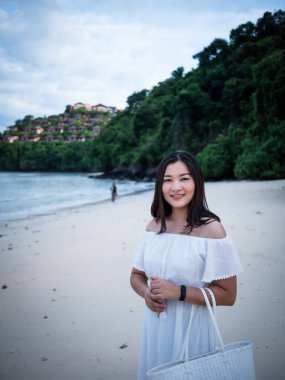 Bir kadın, Tayland 'da huzurlu bir sahil pozu verir. Doğanın güzelliği arasında seyahat ruhunu kucaklar..