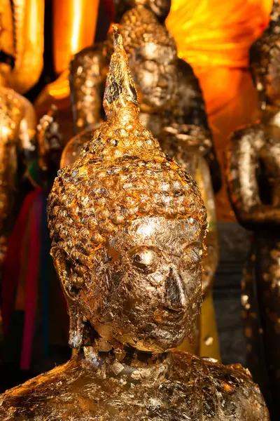 Canlı bir tapınaktaki altın Budist heykellerinin karmaşık detaylarını araştırın..