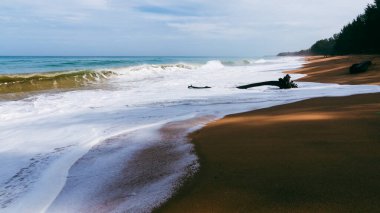 Bu büyüleyici doğa fotoğrafında sakin bir sahile vuran dalgaların dingin güzelliğini hissedin..