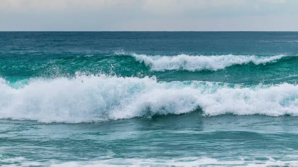 Sakin bir okyanus sahilinde dalgaları çarpıştırmanın huzur veren güzelliğini hissedin..