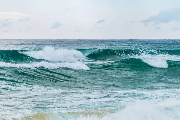 Okyanus dalgalarının doğal manzarasını deneyin. Huzurlu bir sahile çarpıp doğanın sanatını gösterin..
