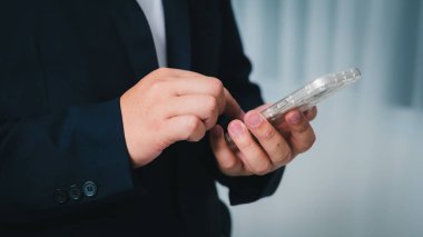 Bir profesyonel, dijital iletişim işinin önemini vurgulayan bir ofisin akıllı telefonuyla bağlantı kurar..