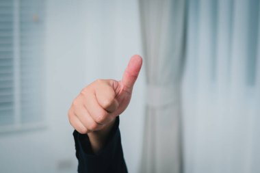 Başarıyı işaret eden olumlu bir el hareketi iş bağlamında güç ve başarı vurgulanıyor..