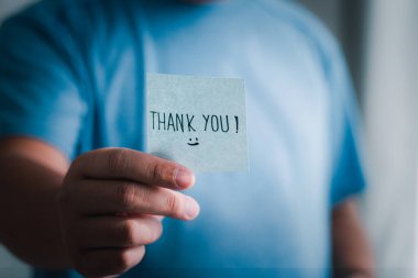 Bir el olarak çekilen samimi bir an minnettarlığı simgeleyen bir teşekkür notu sunar..