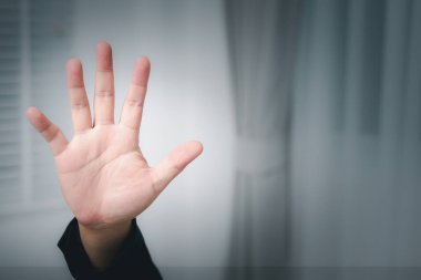 Sözsüz iletişimi, sessiz bir iç mekan ayarını sergilemeyi bırakması için bir el işaretinin yakın çekimi..