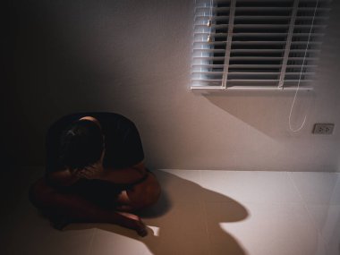 Bir adam derin bir duygusal acı ve umutsuzluk yaşar loş ışıklı bir alan depresyonla mücadele eder..