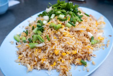 Bu canlı vitrinler, taze soğan ve otlarla kaplı kızarmış pirinçle dolu, hareketli bir sokak pazarında..