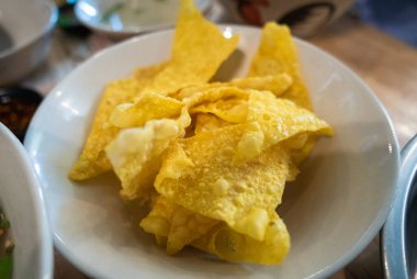 Canlı bir tabak altın tortilla cipsi yerel bir lokantada servis edilir ve sıcak bir yemek atmosferi sergilenir..