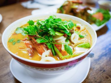 Canlı bir kase şehriye çorbası taze otlarla süslenmiş sokak yemeği kültürü sergileniyor..