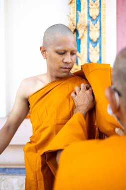 Chachoengsao, Tayland-13 Kasım 2023: Tayland Budist değerleri ve toplum ruhunu somutlaştıran geleneksel bir koordinasyon törenine katılan genç bir keşiş.