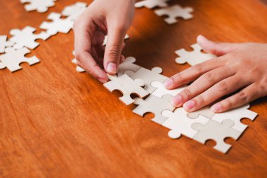 Bir insan karmaşık bir bulmacayı tamamlamaya odaklanır. Konsantrasyon ve yaratıcılık gösterir..