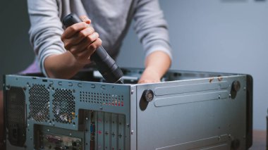 Bir kişi bilgisayarı tamir ettiğini gösterir. Bir ev atölyesi DIY becerilerini ön plana çıkarır. Yakın plan bir çekim..