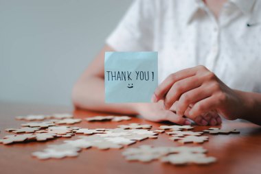 Bir insan, takdir işini vurgulayan bulmaca parçalarının arasında elle yazılmış bir notla minnettarlığını ifade eder..