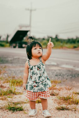 Bebek bir kız gökyüzünü işaret eder. Merakı ve aile hayatının güzelliğini..