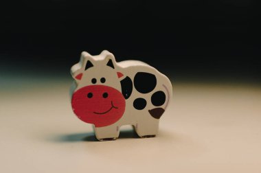 Neşeli bir inek heykelciği, kapalı alanda oyuncaklar sergiliyor. .