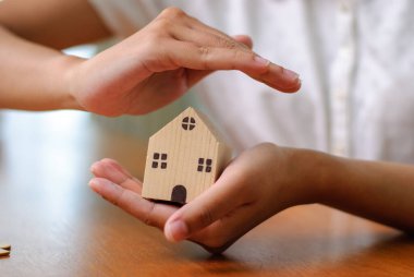 Minyatür bir evin korunması, ev güvenliğinin önemini vurguluyor..