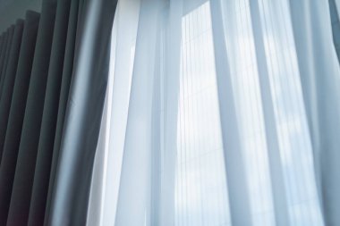 Saf perdelerden süzülen yumuşak doğal ışık kapalı alan minimalist estetik ortamında