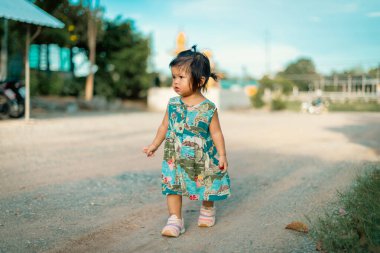 Kırsal kesimde tozlu bir yolda yürüyen çocuk gün ışığına çıktı.