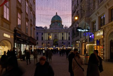 VIENNA, Austria - January 6, 2023: Kohlmarkt, pedestrian luxury shopping street just outside Hofburg palace, crowded with people in the evening clipart