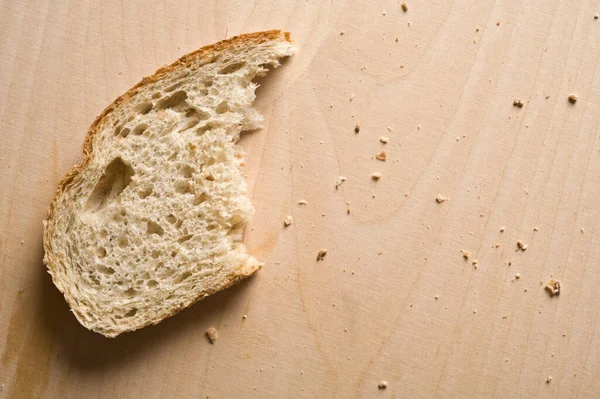 Pół Zjedzony Kawałek Chleba Drewnianym Stole — Zdjęcie stockowe
