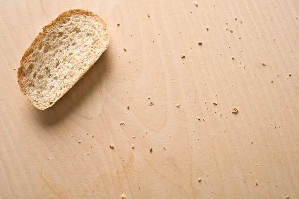 Kromkę Chleba Drewnianym Stole — Zdjęcie stockowe