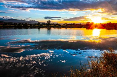 Gölün üzerinde fırtına bulutlarıyla gün batımı. HDR Resmi (Yüksek Dinamik Aralık).