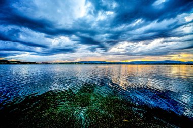 Gölün üzerinde fırtına bulutlarıyla gün batımı. Göldeki fırtına, HDR görüntüsü (Yüksek Dinamik Menzil).