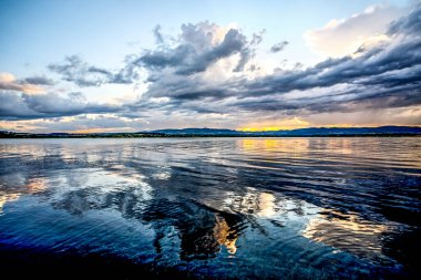 Gölde gün batımı. Fırtınadan önceki fırtına bulutlarının ardında güzel bir günbatımı. Gün batımında bulutlu dramatik bir gökyüzü. HDR resmi (Yüksek Dinamik Aralık).