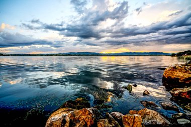 Gölde gün batımı. Fırtınadan önceki fırtına bulutlarının ardında güzel bir günbatımı. Gün batımında bulutlu dramatik bir gökyüzü. HDR resmi (Yüksek Dinamik Aralık).