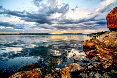 Gölde gün batımı. Fırtınadan önceki fırtına bulutlarının ardında güzel bir günbatımı. Gün batımında bulutlu dramatik bir gökyüzü. HDR resmi (Yüksek Dinamik Aralık).