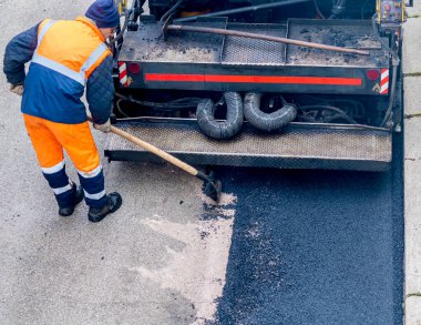 Road Street tamirat sırasında kaldırım taşıma makinesinde çalışan bir işçi. Seçici odak
