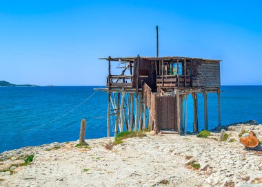 Geleneksel bir İtalyan ahşap balıkçı evi olan Adriyatik Denizi 'ne bakan Trabucco (Trabocco, Trebuchet). Apulian sahilinde balık tutmak için Stilt House. Apulia - İtalya