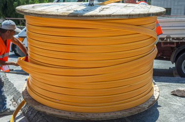 İşçi yeni geniş bant altyapısı için fiber optik kabloların yerleştirileceği pvc kablosunu açar